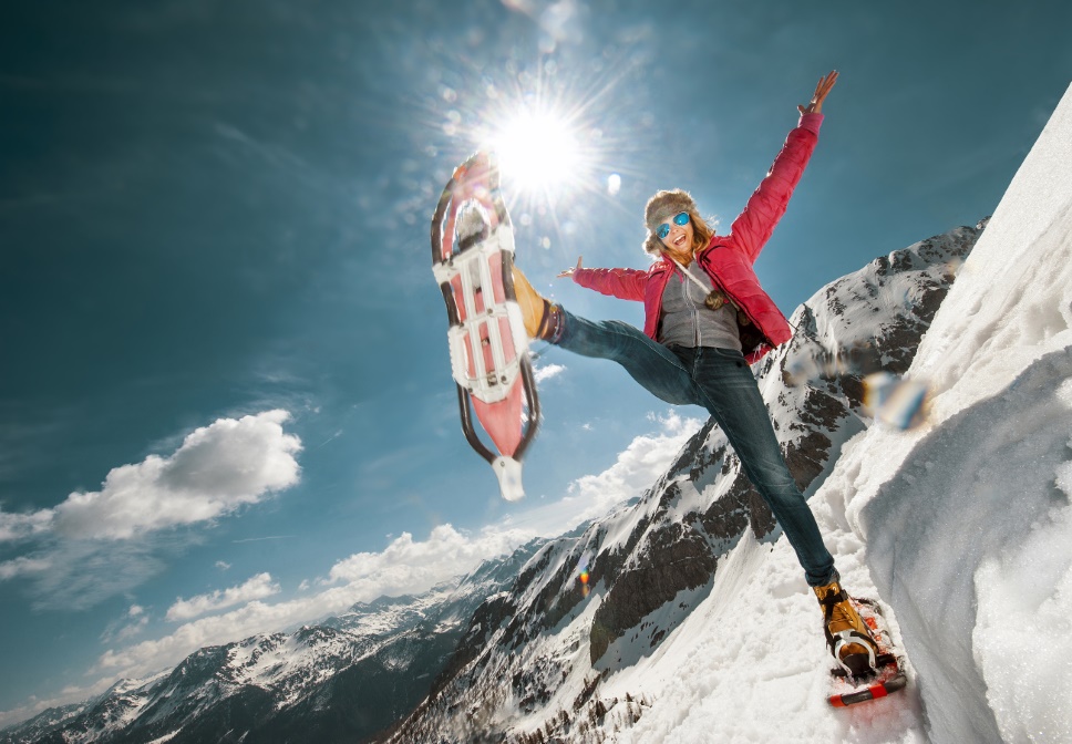 Woman with snowshoes makes a funny pose.