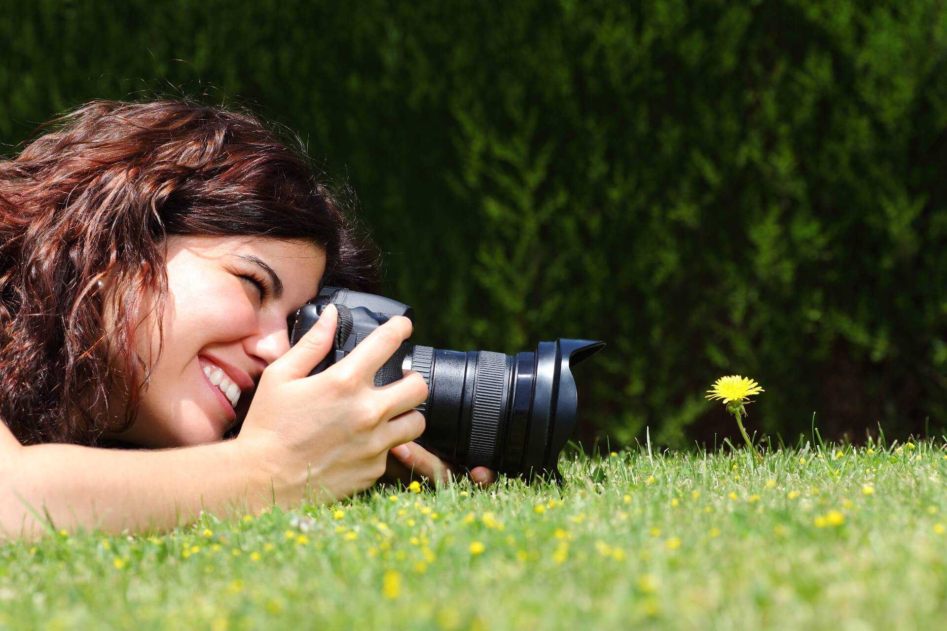Une photographe prend une photo d’une fleur de près Une photographe prend une photo d’une fleur de près